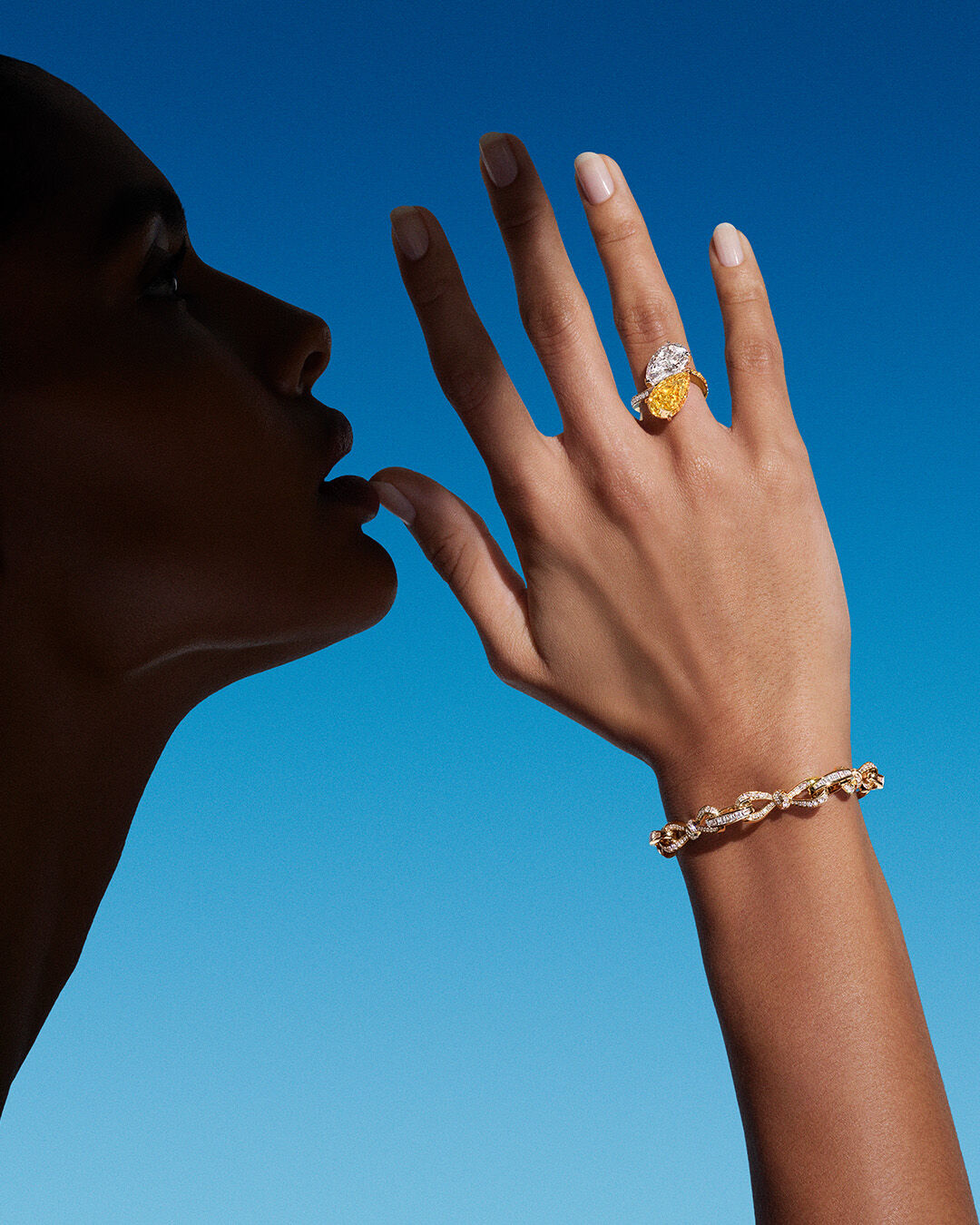 Model wears a yellow and white diamond ring and Tilda's Bow bracelet