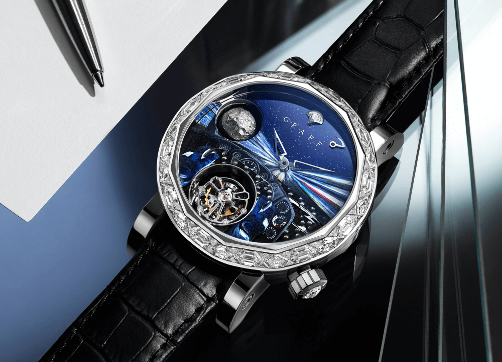 A Graff Men's GyroGraff Vintage Drive watch with white gold diamond bezel on a desk with stationeries