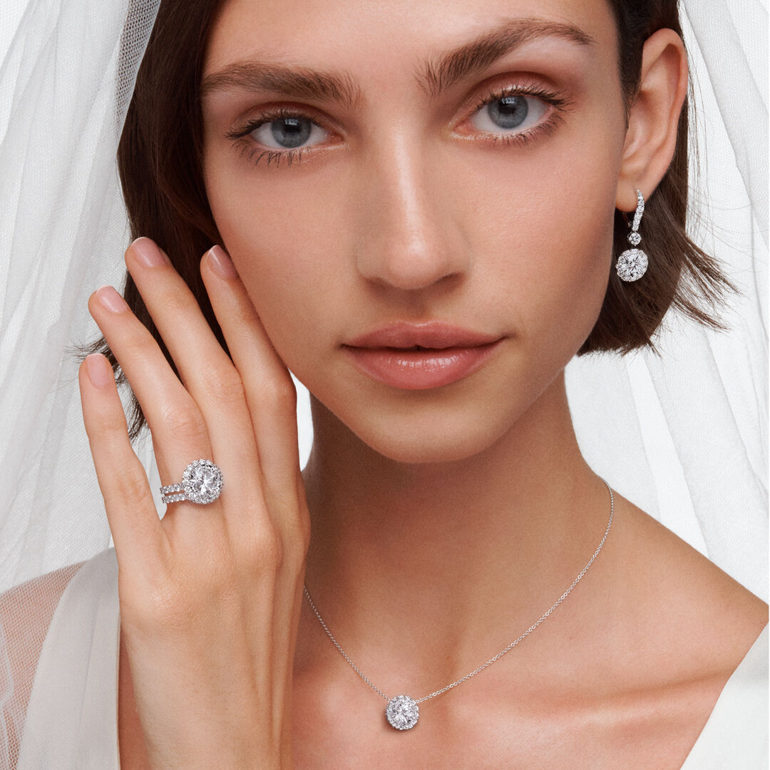 Image of model wearing Graff Icon Round Engagement ring and Icon white diamond necklace and earrings