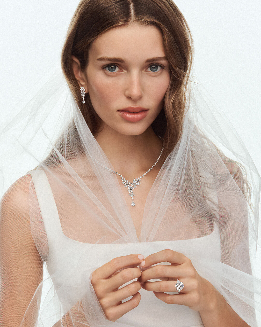 Image shows model wearing Graff Promise Round Diamond Cut engagement ring and Graff Butterfly diamond jewellery suite